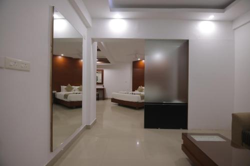 a bedroom with two beds and a large mirror at Nakshatra Emerald in Guruvāyūr
