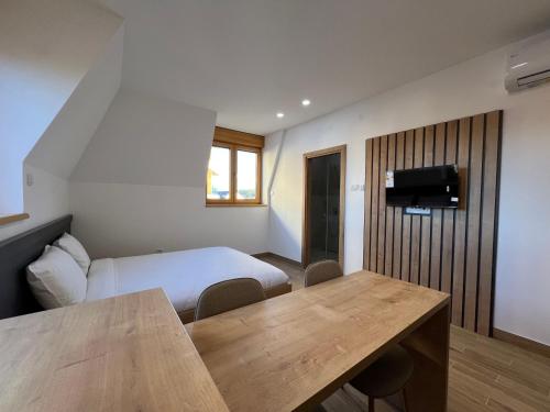 a bedroom with a bed and a table in a room at Zlatni Odmor (Centar) in Zlatibor