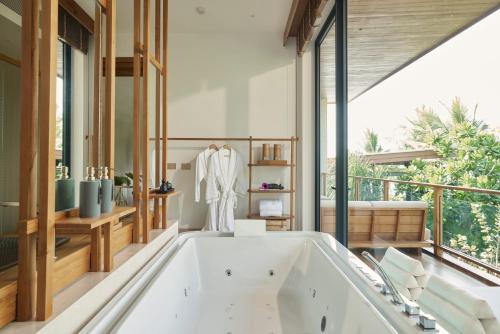 a bath tub in a bathroom with a large window at The Retreat, Koh Chang in Ko Chang