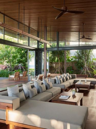 a living room with couches and tables and windows at The Retreat Koh Chang, an SLH Hotel in Ko Chang