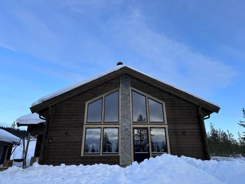 ein Haus mit einem großen Fenster im Schnee in der Unterkunft Vinterdröm Idre Himmelfjäll in Idre