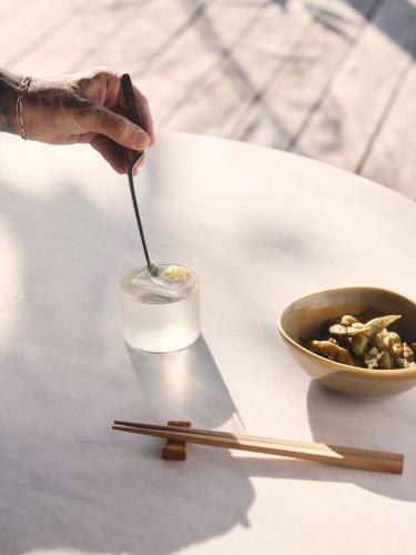 a person is stirring a drink with a spoon at The Retreat Koh Chang, an SLH Hotel in Ko Chang