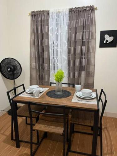 a dining room table and chairs with a window at ESTILO APARTMENT 2-storey in Clarin