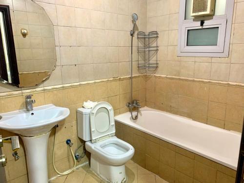 La salle de bains est pourvue d'un lavabo, de toilettes et d'une baignoire. dans l'établissement Falcon Living Hostel, à Dubaï