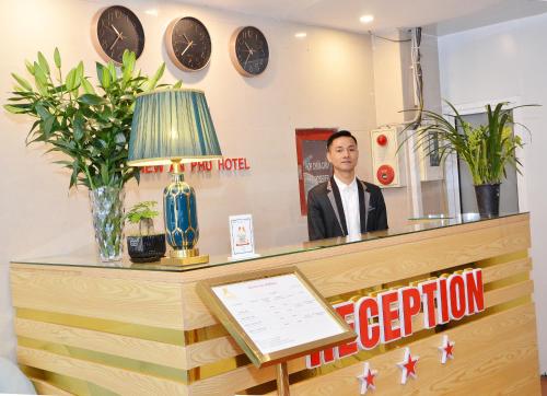 a man standing behind a counter in a store at New An Phú Hotel in Dong Anh