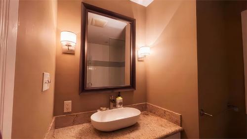 a bathroom with a sink and a mirror at Cozy Home near Eglinton west Station Toronto! in Toronto