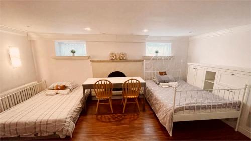 Habitación con 2 camas, mesa y sillas en Cozy Home near Eglinton west Station Toronto!, en Toronto