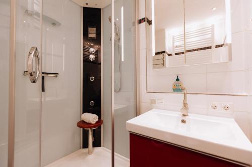 a white bathroom with a sink and a shower at Weideglück-Zentral-Dampfdusche in Oberstaufen