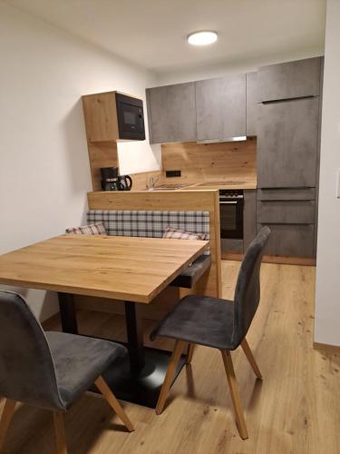 a kitchen with a wooden table and two chairs at Zimmer & Appartements Schwarzenbacher Sonja & Konrad in Kleinarl