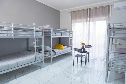 a bedroom with bunk beds with a table and a chair at Hostel Partenope in Naples