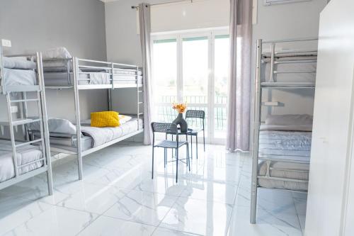 a room with bunk beds with a table and a chair at Hostel Partenope in Naples