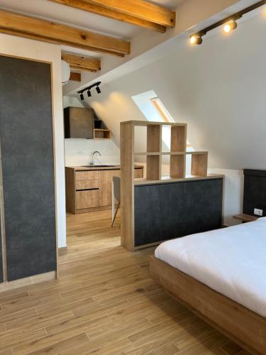 a bedroom with a large bed and a kitchen at Zlatni Odmor (Centar) in Zlatibor