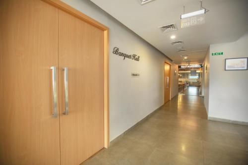 a hallway in a hospital with a sign on the wall at Raj Riveria Hotel in Mūvattupula