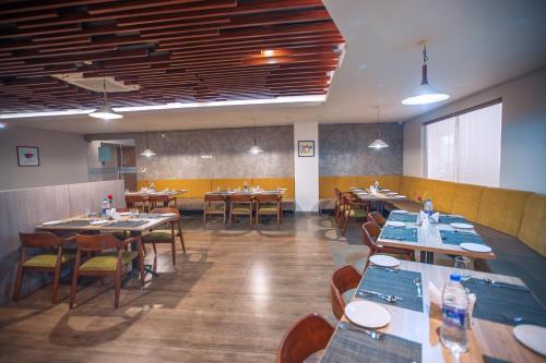 a dining room with tables and chairs in a restaurant at Raj Riveria Hotel in Mūvattupula