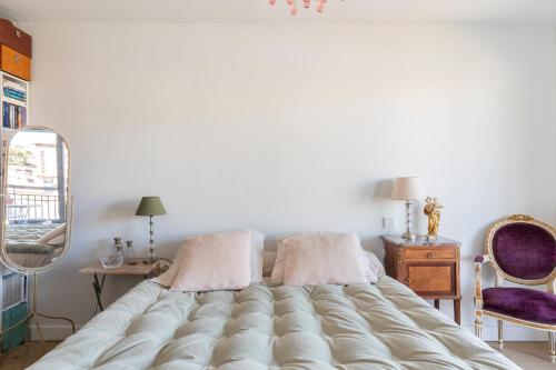 a large bed with two pillows in a bedroom at Vue plongeante sur l'eau in Saint-Jean-de-Luz