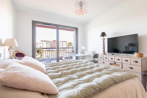 a large couch in a living room with a television at Vue plongeante sur l'eau in Saint-Jean-de-Luz
