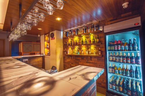 a bar with a lot of bottles of alcohol at Raj Riveria Hotel in Mūvattupula
