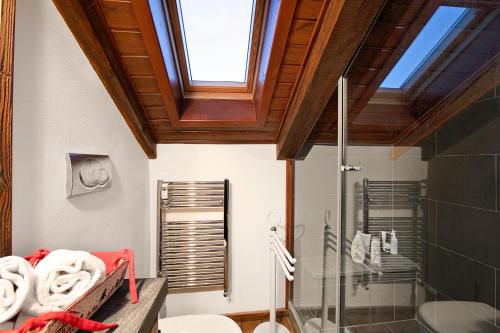 a bathroom with a shower and a toilet and a window at Appartamento La Fontaine Ski In Ski Out - Happy Rentals in Claviere