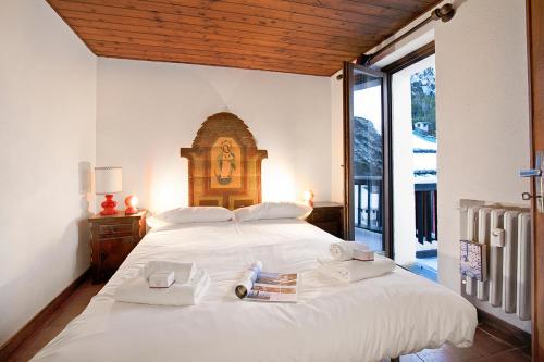 a bedroom with a large white bed with towels on it at Appartamento La Fontaine Ski In Ski Out - Happy Rentals in Claviere