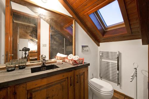 a bathroom with a toilet and a sink and a window at Appartamento La Fontaine Ski In Ski Out - Happy Rentals in Claviere