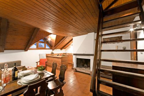 a dining room with a table and a fireplace at Appartamento La Fontaine Ski In Ski Out - Happy Rentals in Claviere