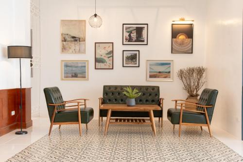 a living room with a couch and two chairs and a table at Bania Boutique House in Khao Lak