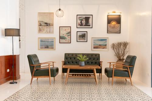 un soggiorno con divano, 2 sedie e tavolo di Bania Boutique House a Khao Lak
