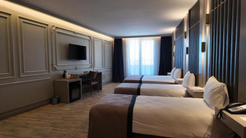 Un pat sau paturi într-o cameră la Lala Grand Hotel