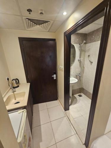 a bathroom with a brown door and a sink and a shower at فندق شاكر in Makkah