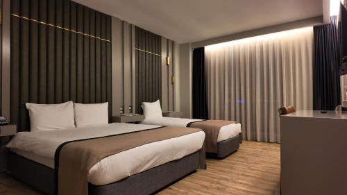 Un pat sau paturi într-o cameră la Lala Grand Hotel