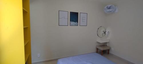 ein weißes Zimmer mit einem Bett und einem Ventilator in der Unterkunft Casa com piscina em Pontal do Paraná - Balneário de Ipanema in Pontal do Paraná