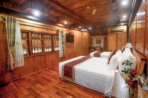 a bedroom with a bed in a wooden room at Thung Nham Resort in Ninh Binh