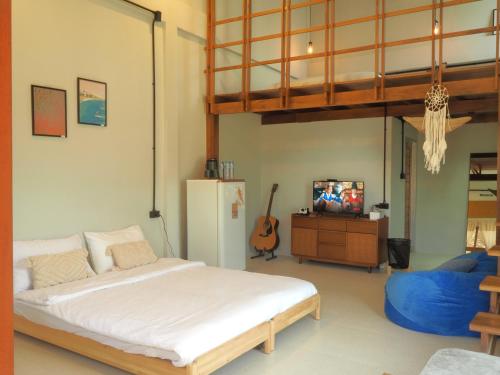a bedroom with a large bed and a refrigerator at Makai NAP in Ban Lam Pi