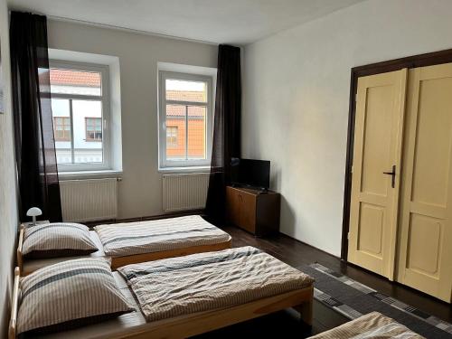 two beds in a room with two windows at Hostel RK in Horažďovice