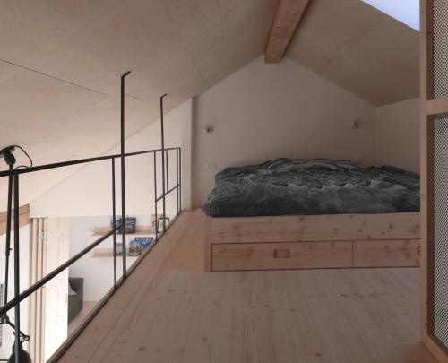 een slaapkamer met een bed op een houten vloer bij House Design Vipiteno in Vipiteno