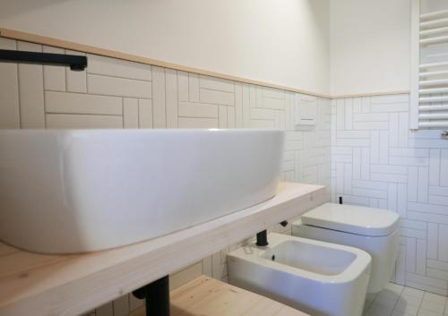a white bathroom with a sink and a toilet at House Design Vipiteno in Vipiteno