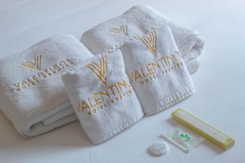 duas toalhas brancas com as palavras "alfmination" nelas em Valentino's Hotel em Angeles