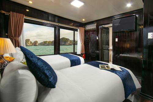 duas camas num quarto com vista para a água em Ha Long Fantasea Legend Cruise em Ha Long