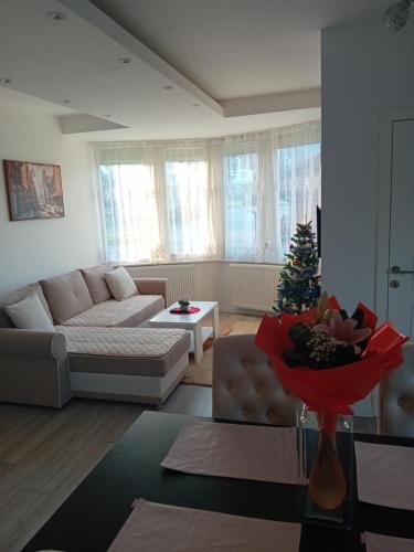 a living room with a couch and a christmas tree at Konak Cicović in Pale