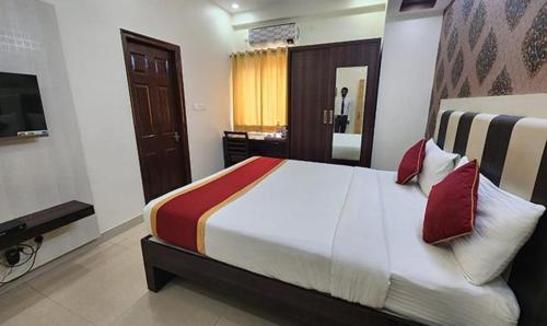 1 dormitorio con 1 cama grande y TV en FabHotel Panchami Comforts en Bangalore