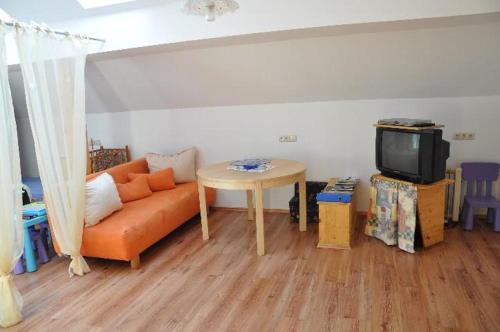 ein Wohnzimmer mit einem orangenen Sofa und einem Tisch in der Unterkunft Haus Schober in Windischgarsten