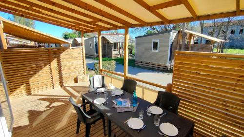 a patio with a table and chairs on a deck at Camping Les Palmiers in Hyères