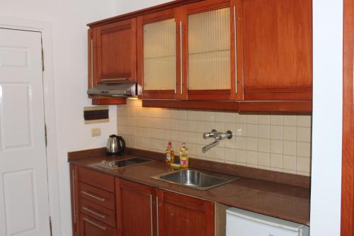 a kitchen with wooden cabinets and a sink at Herrmes Hostel in Sharm El Sheikh
