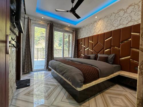 a bedroom with a large bed with a wooden headboard at Rabha Stay 2BHK Penthouse with Terrace in Rishīkesh
