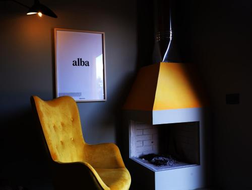 krzesło i lampa w pokoju z kominkiem w obiekcie PODERE DELL'ETNA SEGRETA - Essential Nature Hotel w mieście Biancavilla