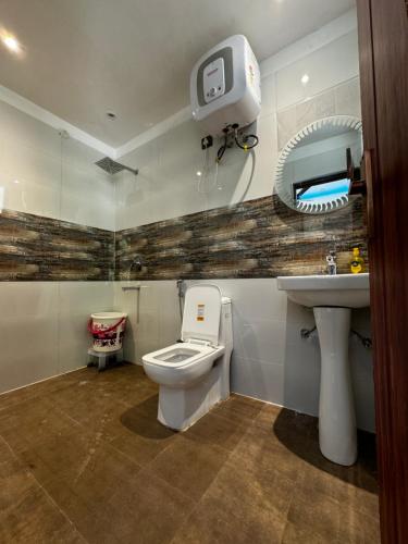 a bathroom with a toilet and a sink at Rabha Stay 2BHK Penthouse with Terrace in Rishīkesh