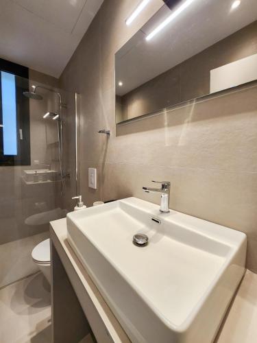 a bathroom with a white sink and a toilet at Villa Blauw with Infinity Pool & Sea Views in Vasiliki