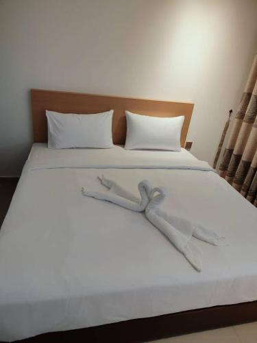 a large white bed with a bow tie on it at One Dream Hotel in Petaling Jaya