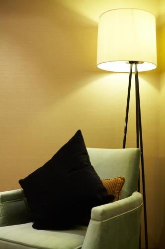 a lamp sitting next to a couch with a pillow at Jin Jiang Tower in Shanghai