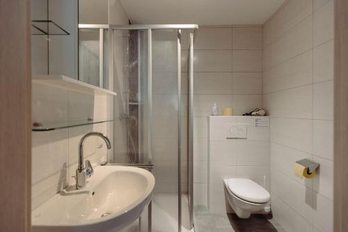 a bathroom with a shower and a sink and a toilet at Stangl Appartements in Flachau